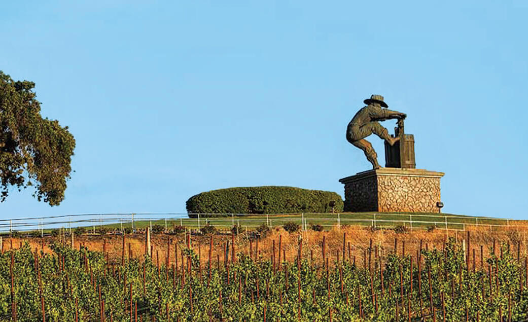 Napa-grape-crusher-statue-and-vineyards-1