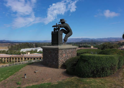 grape-crusher-statue-with-mountains-in-background